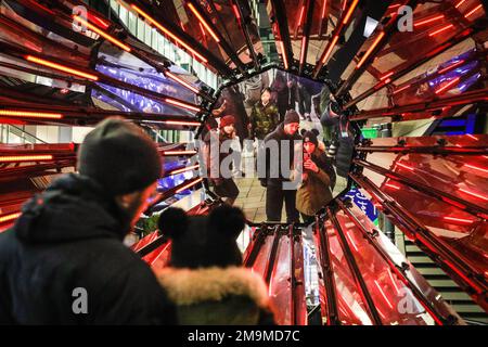 Londres, Royaume-Uni. 18th janvier 2023. Les gens regardent et prennent des photos de Out of the Dark par Tom Lambert, juste à l'extérieur de Crossrail place, une installation de lumière audiovisuelle offrant un espace pour l'auto-réflexion et la positivité.le festival annuel des lumières d'hiver est lancé aujourd'hui avec 22 installations lumineuses et expositions d'art immersives disséminées autour de Canary Wharf à Londres. Le festival public se déroule jusqu'au 28th janvier et est gratuit à visiter. Credit: Imagetraceur/Alamy Live News Banque D'Images