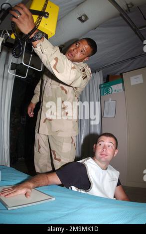 Pendant l'opération LIBERTÉ IRAQUIENNE, le sergent d'ÉTAT-MAJOR (SSGT) de l'US Air Force (USAF) Justin Stewart, 40th Expeditionary Medical Squadron (EMDS) se prépare à rayons X USAF SSGT Zachary King's Fingers pour s'assurer qu'il n'y a pas de pauses. Objet opération/série: LIBERTÉ IRAQUIENNE pays: Inconnu Banque D'Images