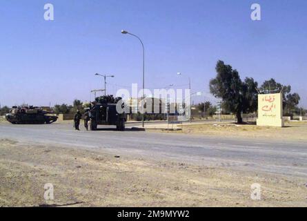 Avec leur corps des Marines des États-Unis (USMC) M1A1 Abrams main Battle Tank (MBT) et Assault Amphibian Vehicle personnel (AAVP7A1) en place, le personnel de l'équipe de combat 1 (RCT1), occupent la route 7 à travers la ville d'Al Fay, en Irak, pour soutenir l'opération LIBERTÉ IRAKIENNE. Objet opération/série: LIBERTÉ IRAQUIENNE pays: Irak (IRQ) Banque D'Images