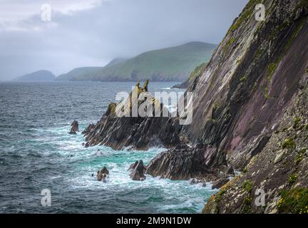 Les vagues s'écrasant dans les falaises, il s'agit de la péninsule de Dingle sur la voie de l'Atlantique sauvage en Irlande, sur la côte atlantique sud-ouest. Banque D'Images