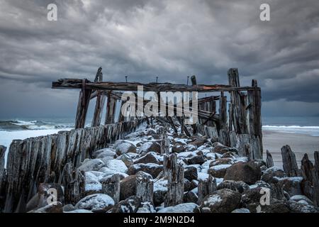 Nuages orageux d'hiver et un ancien pont sur la mer Baltique à Šventoji, Lituanie Banque D'Images