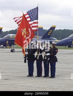 Une Garde de couleur du corps des Marines des États-Unis (USMC) présente les couleurs à l'ouverture du salon de l'air qui s'est tenu à la Marine corps Air Station (MCAS) Cherry point, en Caroline du Nord (NC). Les avions F/A-18 Hornet des US Navys (USN) de l'équipe de démonstration aérienne des US Blue Angels sont visibles en arrière-plan. Base : MCAS, Cherry point État : Caroline du Nord (NC) pays : États-Unis d'Amérique (USA) Banque D'Images