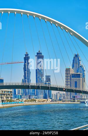 DUBAÏ, Émirats Arabes Unis - 6 MARS 2020 : Canal d'eau de Dubaï avec pont de tolérance piétonnier moderne et horizon futuriste de la ville en arrière-plan, sur 6 mars à Dubaï Banque D'Images