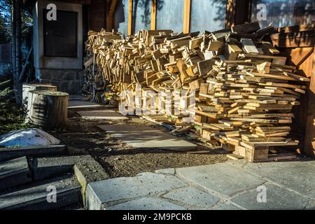 Un tas de bois de chauffage empilés, préparé pour le chauffage de la maison, récolté pour le chauffage en hiver sur le mur de la maison Banque D'Images