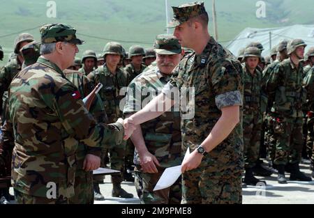 Un officier non identifié de l'armée de la République de Géorgie (à gauche), affecté au bataillon des montagnes de 16th, présente le capitaine (CPT) du corps des Marines des États-Unis (USMC) Mark carter, du programme train et équip de la Force opérationnelle en Géorgie (GTEP), avec un signe d'appréciation de la part du ministre géorgien de la Défense, lors d'une cérémonie de certification, Tenue dans la zone d'entraînement de Krtsanisi, à Rock City, en Géorgie. La cérémonie marque l'achèvement de la troisième phase d'entraînement tactique pour les soldats participant au programme. Le GETEP est une initiative de formation progressive qui améliore les capacités opérationnelles de certaines unités géorgiennes à incrémente Banque D'Images