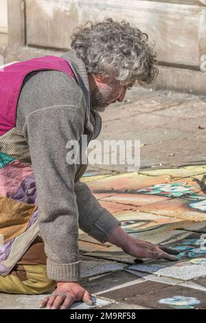 Un artiste de rue fait un dessin de craie de chaussée dans une place à Venise, en Italie. Banque D'Images