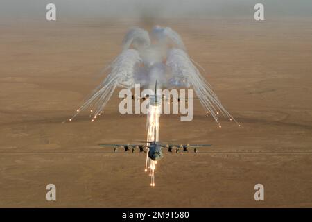 Un avion Hercules KC-130 du corps des Marines des États-Unis (USMC) affecté à l'escadron de transport aérien deux trois quatre (VMGR-234) lance une exposition de fusées éclairantes de contre-mesures, tout en volant une formation de fuite avec un deuxième avion au-dessus du désert en Irak, pendant l'opération LIBERTÉ IRAQUIENNE. Objet opération/série: LIBERTÉ IRAQUIENNE pays: Irak (IRQ) Banque D'Images