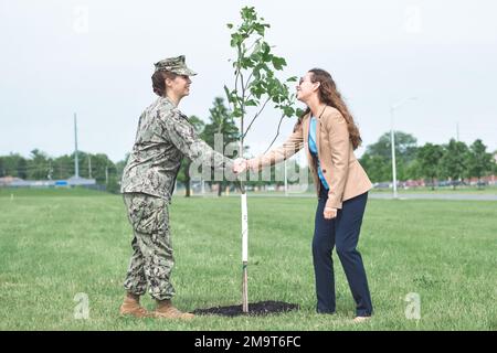 Defense Logistics Agency Land and Maritime Commander États-Unis Kristen Fabry, SMA de la Marine arrière, Shakes Defense Supply Centre Columbus Division de la protection de l'environnement Chef Nicole Goicochea devant l'arbre de tulipe Goicochea avait planté en souvenir du soutien que Fabry a accordé au programme Tree City USA pendant son mandat ici. Banque D'Images