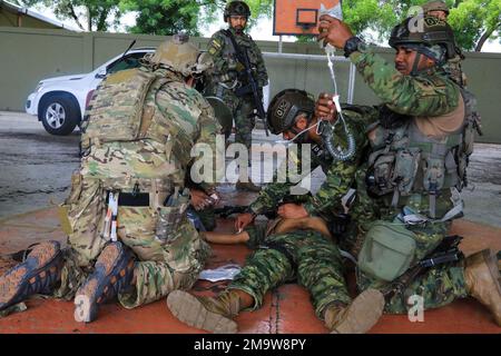 Un membre des Forces spéciales équatoriennes prépare une intraveineuse pour une causalité tandis qu'un médic de 7th forces spéciales traite les autres blessures subies par une causalité lors d'un raid sur un bâtiment ennemi à Manta, Equateur, 21 mai 2022. L'armée équatorienne et les forces américaines mènent des échanges militaires de routine depuis 6-27 mai entre les villes de Manta et de Latacunga. Les échanges bilatéraux permettent aux deux militaires de renforcer la préparation tactique pour les opérations futures maintenir la préparation et le soutien engagement continu en réponse aux crises de sécurité émergentes et aux catastrophes naturelles. (ÉTATS-UNIS Photos de l'armée Banque D'Images