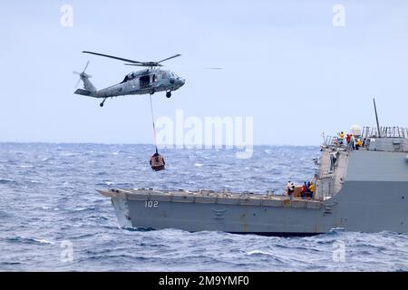 220521-O-NR876-991 MER DES PHILIPPINES (21 mai 2022) un hélicoptère MH-60s Seahawk, affecté à l'Escadron de combat de la mer (HSC) 21, détachement 8, transporte des palettes de fournitures du navire de combat littoral de la classe Independence USS Charleston (LCS 18) au destroyer de la classe Arleigh Burke USS Sampson (DDG 102). Charleston, qui fait partie du Destroyer Squadron (DESRON) 7, est sur un déploiement rotatif, opérant dans la zone d'exploitation de la flotte américaine 7th pour améliorer l'interopérabilité avec les partenaires et servir de force de réaction prête à l'appui d'une région libre et ouverte Indo-Pacifique. Banque D'Images