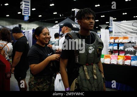 ÉTATS-UNIS Le Cpl. Du corps maritime Stephanie Soto, une Marine de marketing et de communication avec le poste de recrutement de Los Angeles, assiste un participant à l'exposition Fit au Centre des congrès de Los Angeles, Los Angeles, Californie, sur 21 mai 2022. La Fit Expo est la plus grande convention de fitness de la côte ouest où les passionnés se réunissent pour rencontrer des influenceurs, découvrir de nouveaux produits et observer des compétitions. Banque D'Images