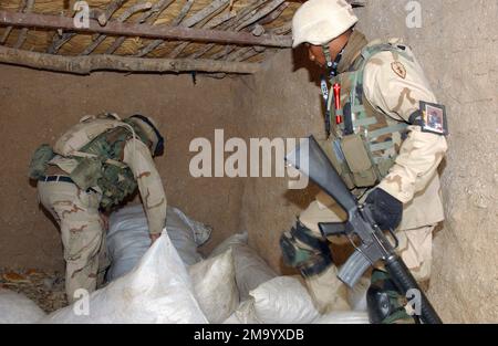 SOLDATS DE l'armée AMÉRICAINE (USA) affectés à 2-11 Artillerie de campagne, perquisitions à travers des sacs de pain séché dans le village de Qarah Tappah, en Irak, pendant l'opération LIBERTÉ IRAQUIENNE. La recherche a été effectuée pour localiser et confisquer toute contrebande illégale pouvant être utilisée contre les forces de la coalition. Objet opération/série: LIBERTÉ IRAQUIENNE base: Qarah Tappah pays: Irak (IRQ) Banque D'Images