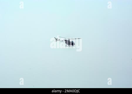 L'hélicoptère de combat vole contre un ciel bleu isolé. L'hélicoptère de combat attaque l'ennemi. Banque D'Images