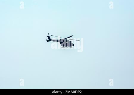 L'hélicoptère de combat vole contre un ciel bleu isolé. L'hélicoptère de combat attaque l'ennemi. Banque D'Images