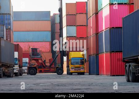 Chariots élévateurs à conteneurs et camions dans la cour des conteneurs accent sur les importations et les exportations Banque D'Images