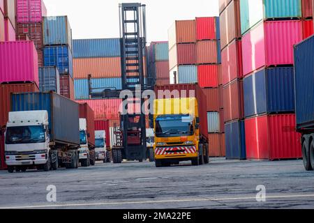 Chariots élévateurs à conteneurs et camions dans la cour des conteneurs accent sur les importations et les exportations Banque D'Images