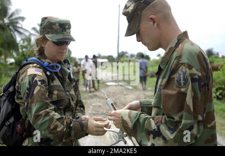 040731-F-0571C-059. [Complet] Légende de la scène: US Army Reserve (USAR) Capitaine (CPT) Melinda Hutton (gauche) et Sergent (SGT) Joseph Thomas (droite), 109th Service vétérinaire du détachement médical (MDVS), 63rd Commandement de la préparation de la réserve (RRC), remplacer une aiguille dans un auto-injecteur tout en effectuant un exercice de préparation vétérinaire (VETETE) à Anna Pomeroon Supenaam (région de Regina) Dans le cadre d'une opération NOUVEAUX HORIZONS 2004. Cette opération est un exercice de formation de service conjoint de quatre mois organisé au Guyana par des éléments du US Southern Command (USSOUTHCOM) et de la Force de défense du Guyana ( Banque D'Images