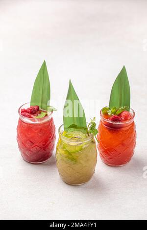 Trois grandes mugs en verre de limonades de fruits assorties Banque D'Images