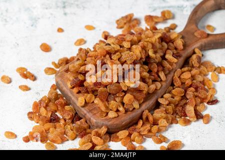 Raisins secs sur fond de pierre. Pile de raisins jaunes bio sur une table de service en bois. Noix saines séchées. gros plan Banque D'Images