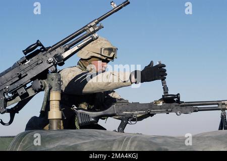 Une troupe du corps des Marines des États-Unis (USMC) du 3rd Marine Aircraft Wing (MAW) Security Battalion, charge son canon à machine FNMI 7,62 mm M240 dans le champ d'armes avant de se lancer dans une patrouille périphérique hors-base à Al Asad, en Irak (IRQ), pour soutenir l'opération LIBERTÉ IRAKIENNE. Objet opération/série: LIBERTÉ IRAQUIENNE base: Al Asad État: Al Anbar pays: Irak (IRQ) Banque D'Images