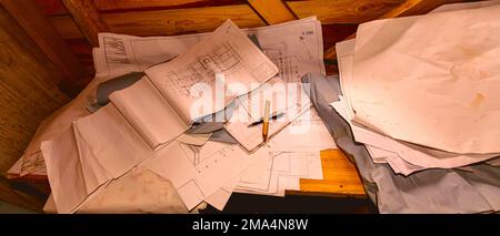 Bureau de travail de Mason dans une cabine en bois avec pile de dessins architecturaux, de plans en papier. Banque D'Images