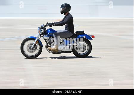 Le petit officier de classe 2nd Justin Edmonston, un technicien en sonar sous-marin à bord de l'USS Texas, apprend à monter à bord d'une moto dans un parcours de base gratuit à la base de la Garde nationale aérienne de Pease, New Hampshire 24 mai 2022. Les cours sont offerts d'avril à novembre et sont gratuits pour tous les membres du ministère de la Défense. Banque D'Images