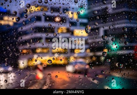 Vue à travers un pare-brise baigné de pluie sur une scène de rue à Francfort Banque D'Images