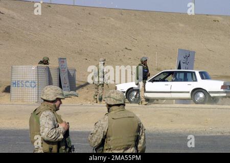 MARINES US Marine corps (USMC) affectées à 31st Marine Expeditionary Unit (MEU), Et les soldats iraquiens surveillent la circulation à un point de contrôle d'entrée, car les citoyens locaux sont autorisés à rentrer dans la ville de Falloujah, en Irak, à la suite d'une opération offensive visant à éliminer les forces ennemies menées par les Marines affectés au BATAILLON 1st, 3rd Marines, à l'appui de l'opération DE LIBERTÉ IRAQUIENNE. Objet opération/série: LIBERTÉ IRAQUIENNE base: Falloujah État: Al Anbar pays: Irak (IRQ) Banque D'Images