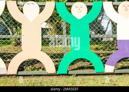 Taupo Nouvelle-Zélande - juillet 2010; rangée de figures découpées de couleurs différentes mais de la même forme en clôture Banque D'Images