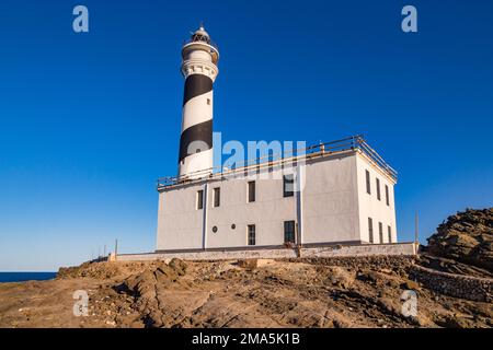 Vue sur les rochers d'ardoise de type lune et le phare de l'idyllique Cap de Favaritx, île de Minorque, Iles Baléares, Espagne Banque D'Images