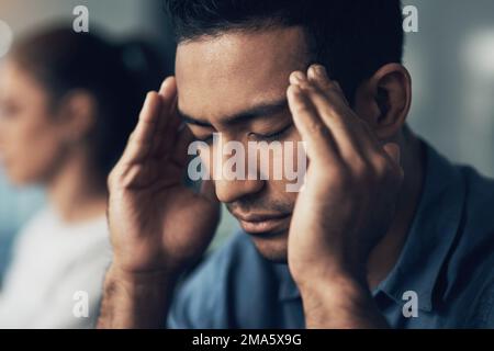 Quelque chose d'aussi vieux que jamais. Gros plan d'un jeune homme souffrant d'une migraine dans un bureau moderne. Banque D'Images