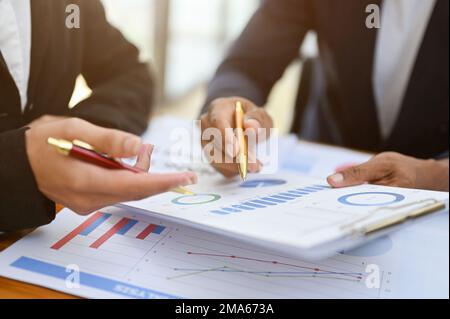 Deux analystes financiers professionnels ou un comptable examinant ensemble les graphiques financiers du rapport, analysant le graphique des données de vente. rogné et gros plan Banque D'Images