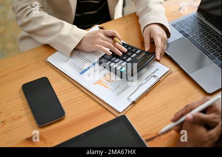 Rognée, vue de dessus, professionnelle femme analyste financier ou comptable discutant et travaillant avec son collègue dans le bureau. Banque D'Images