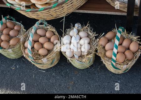 Oeufs frais de la ferme organique dans le panier de paille Banque D'Images