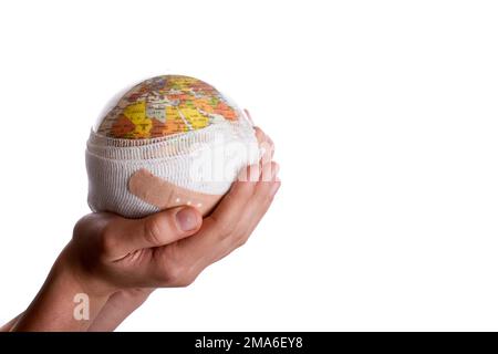 Enfant tenant un globe dans sa main avec du plâtre sur un fond blanc Banque D'Images