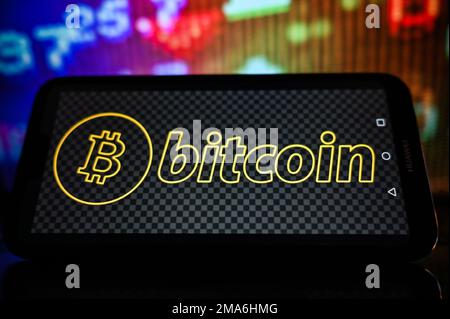 Pologne. 19th janvier 2023. Dans cette illustration, un logo Bitcoin est affiché sur un smartphone avec des pourcentages boursiers sur l'arrière-plan. Crédit : SOPA Images Limited/Alamy Live News Banque D'Images