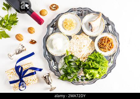 Une assiette d'argent avec des gâteries juives traditionnelles pour la Pâque. œuf, laitue, raifort, os, noix et matzah cuits au four. Un symbole de la Pâque juive Banque D'Images