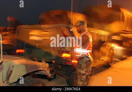 JOSEPH Thorne, 3rd Bataillon (BN), 112th Field Artillery (FA), Garde nationale de l'Armée du New Jersey (NJARNG), Morristown, New Jersey (NJ), guide les véhicules en position lorsqu'ils arrivent à la base intermédiaire près d'Alexandria, Louisiane (LA). Plus de 2 000 véhicules et 4 000 soldats ont été assemblés sur le site central de la Louisiane en attendant de recevoir des commandes pour des missions de récupération le long de la côte du golfe de Louisiane après l'ouragan Rita. (Dupliquer l'image, voir également DFSD0602372 ou rechercher 050925F4970D103). Base: Alexandria État: Louisiane (LA) pays: Uni Banque D'Images