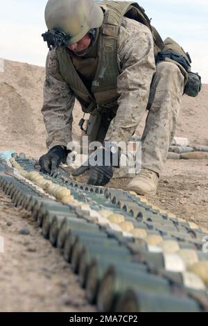 Les techniciens du corps des Marines DES ÉTATS-UNIS (USMC) et de l'Armée des États-Unis (États-Unis) chargés de l'élimination des munitions explosives (EOD), attachés à la Brigade de logistique de combat-8, 2nd Marine Logistics Group (MLG), mettent en scène des munitions non explosées (UXO) au camp Falloujah, en Irak, pendant l'opération LIBERTÉ IRAKIENNE. Les techniciens de l'EOD organisent des munitions confisquées à partir de caches trouvés dans une pile pour détonation. Base: Camp Fallujah Etat: Al Anbar pays: Irak (IRQ) Banque D'Images