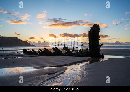 Épave de Helvetia au coucher du soleil, plage de la baie de Rhossili, pas de personnes. Gower Peninsula, pays de Galles du Sud, Royaume-Uni, GB. Banque D'Images