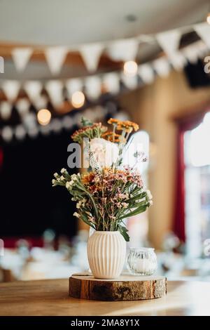 Schöne bunte Blumen in weißer Vase als Hochzeitsdekoration Banque D'Images