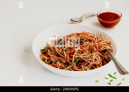 Méin de vache frite à l'asiatique avec sauce photo alimentaire à angle bas sur fond blanc Banque D'Images