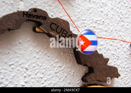 Le drapeau de Cuba sur la punaise à fil rouge a montré les voies de mouvement ou les zones d'influence dans l'économie mondiale sur la carte du bois. Planification de voyages ou concept logistique. Connexion réseau. Banque D'Images