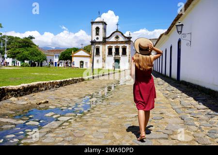 Tourisme au Brésil. Vue arrière de la belle fille avec marche vers l'église de Sainte Rita de Cassia à Paraty, Brésil. Banque D'Images