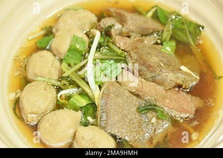 bœuf braisé bouilli et boulettes de viande dans une soupe aux herbes noires sur un bol Banque D'Images