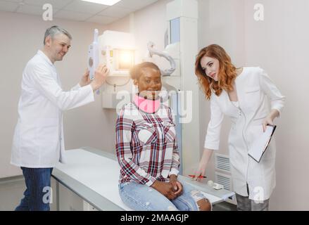 Les radiologues préparent un patient afro-américain à l'imagerie radiologique en laboratoire Banque D'Images