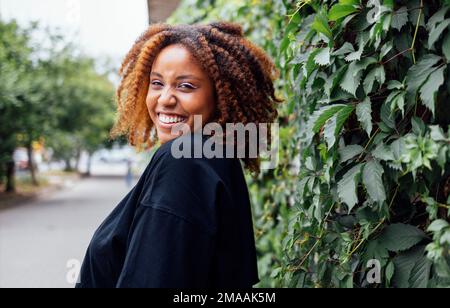 Photo en gros plan de cheveux ondulés charmante peau sombre et gaie personne de bonne humeur agréable week-end de visites à l'extérieur Banque D'Images