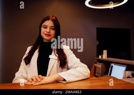 Brunette femme réceptionniste travaillant à la réception du salon de beauté Banque D'Images