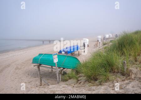 10.09.2022, Allemagne, Mecklembourg-Poméranie occidentale, Graal-Mueritz - balises de plage et bateaux dans la brume matinale sur la plage de sable de la mer Baltique Banque D'Images