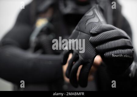 A ÉTATS-UNIS Marine avec 1st Bataillon de reconnaissance, Compagnie Alpha, 13th Marine Expeditionary Unit, met des gants pendant l'entraînement de soutien de plongée sous-marine au camp Pendleton, Californie, 24 mai 2022. Le raffinement des techniques avancées d'infiltration et d'exfiltration de plongée permet au commandant du MEU d'employer des équipes de reconnaissance dans des environnements opérationnels pendant son déploiement. Banque D'Images